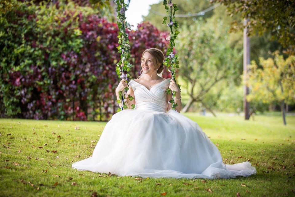A bride with hair by Hair Angels Wedding and Occasions on a swing at Solton Manor, Dover, Kent, England