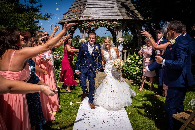 Image of a couple showered in confetti in Godric's Garden at Solton Manor, near Deal in Kent