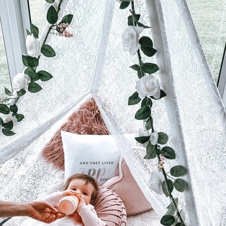A child in a tent inside the Dutch Barn at Solton Manor, near Canterbury, Kent, England