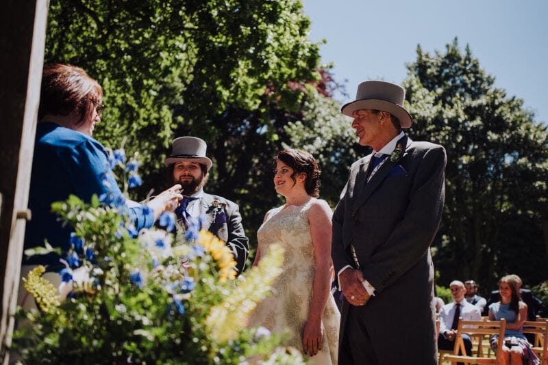 A celebrant officiates a wedding in Godric's Garden at Solton Manor in Kent, England