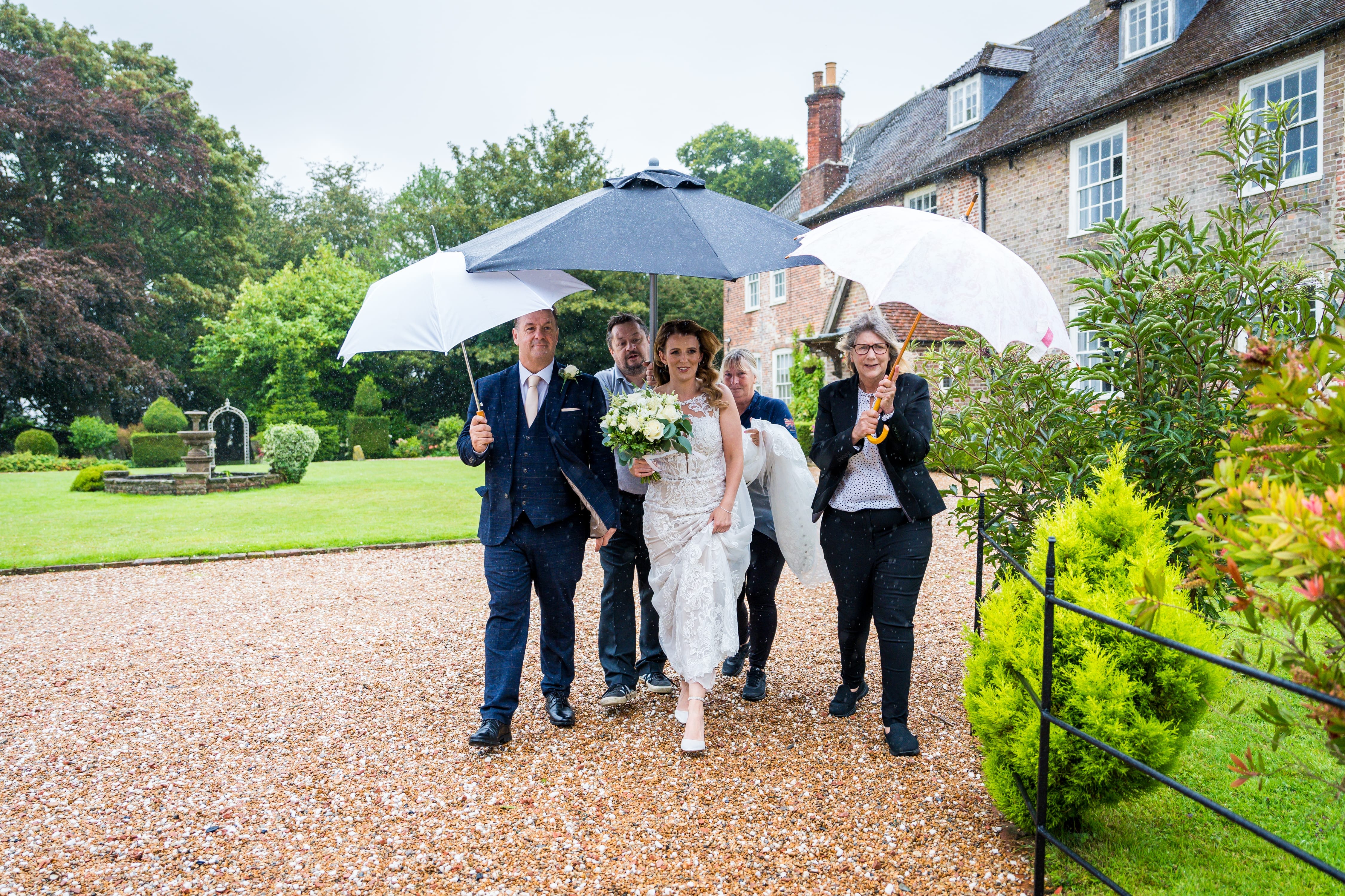 A bridal party makes their way from the Solton Manor House across the garden