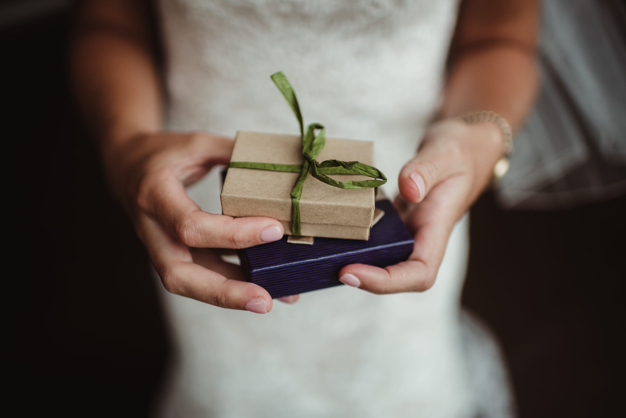 A bride holds two small gifts for her bridal party at Solton Manor near Deal