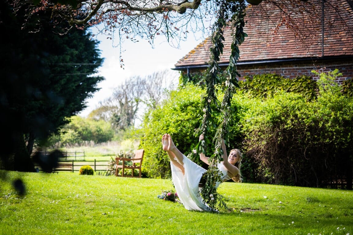 A barefooted bride on a swing at Solton Manor, Dover, Kent, England