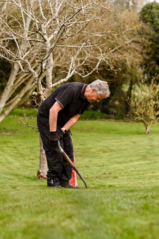 Tom the Gardener at Solton Manor, Dover, Kent, England planting an apple tree in the old Orchard