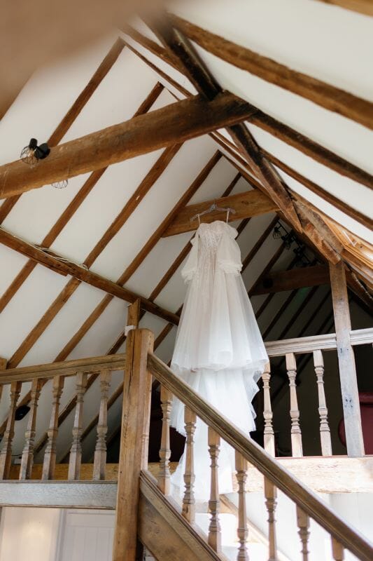 Kaitlyn's wedding dress hung above the stairs in the getting ready Garden Suite at Solton Manor, near Dover Kent