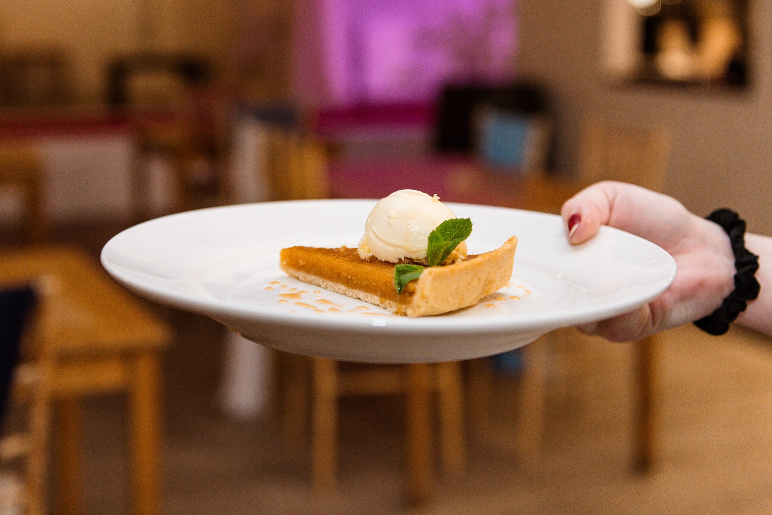 A member of staff holds a slice of dessert during a Tasting Evening at Solton Manor, East Langdon, Dover, Kent, England