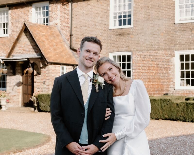A just married couple stand in front of Solton Manor, Dover, Kent, England