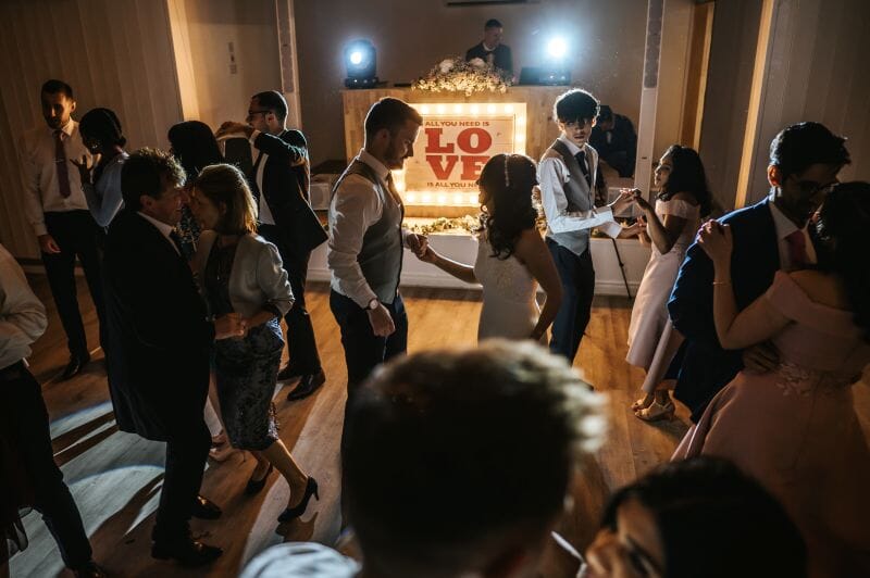 A just married couple dancing at their wedding reception to one of our trusted suppliers in the Dutch Barn at Solton Manor, Dover, Kent, England