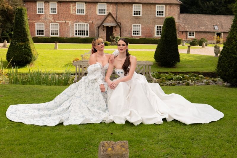 Two brides sit outside Solton Manor house in Kent, Dover, England