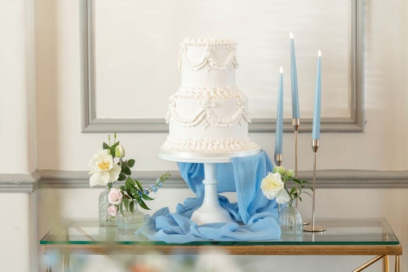 A Lambeth cake by Shelley's Cake displayed in the Gallery Room for an intimate wedding within Solton Manor, Dover, Kent, England