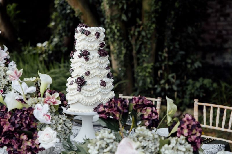 A styled table, with a Lambeth Cake set up outside Solton Manor Country House on the Ponte Vecchio Bridge, Kent, England