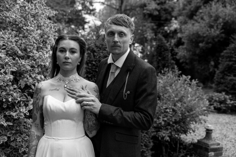 A black and white photo of a just married couple at Solton Manor - she wears of lace collar