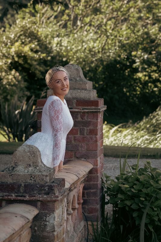 A bride in a vintage dress standing on the Ponte Vecchio Old Bridge at Solton Manor, between Dover and Deal in Kent