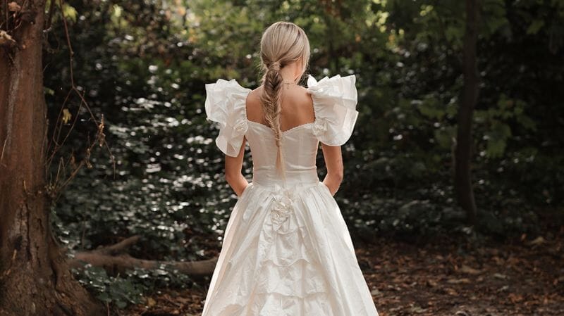 A bride stands in the woodland ceremony area at Solton Manor - a shady outdoor spot for hot summer weddings